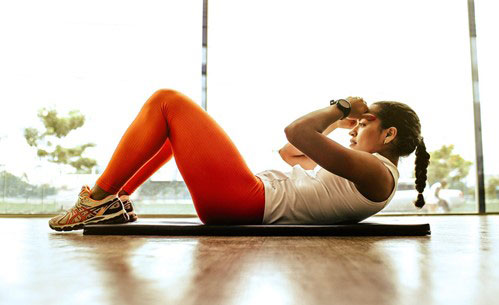 A-woman-doing-sit-ups-indoors